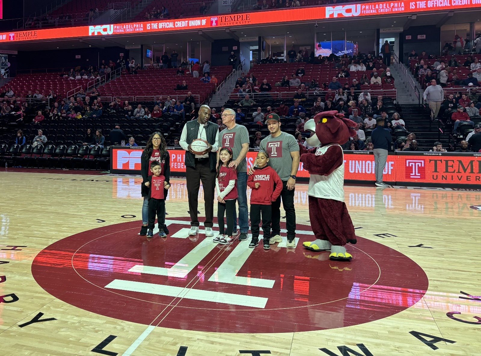 PFCU Treasurer of the Board Joseph F. McHugh, Jr. took to the court to accept the game ball from Director of Temple Athletics, Arthur Johnson.
