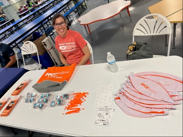 Woman at PFCU booth with free PFCU items.