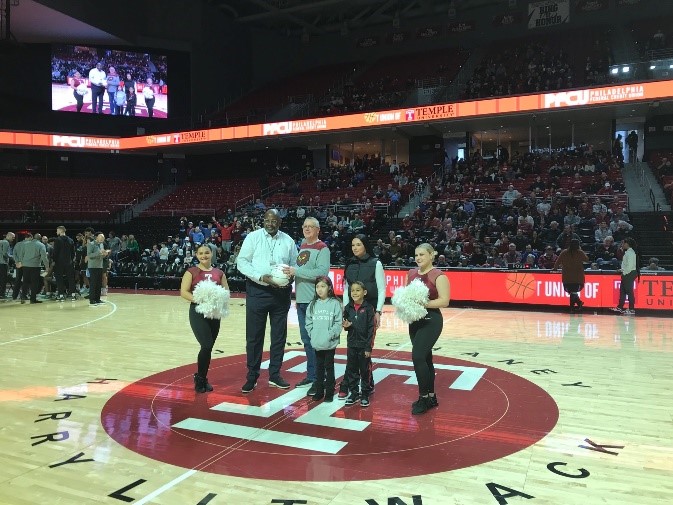 PFCU treasurer and Temple University Director of Athletics on basketball court.