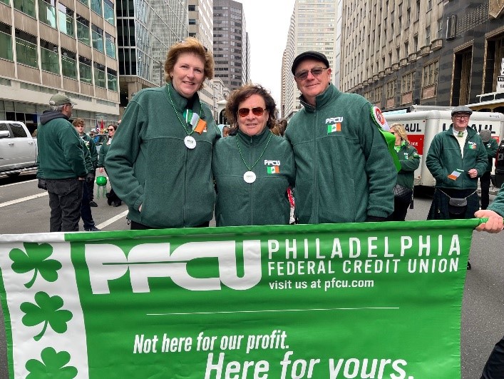 PFCU employees with PFCU banner at St. Patrick's Day Parade.