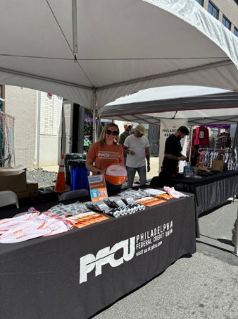Woman standing at PFCU booth.