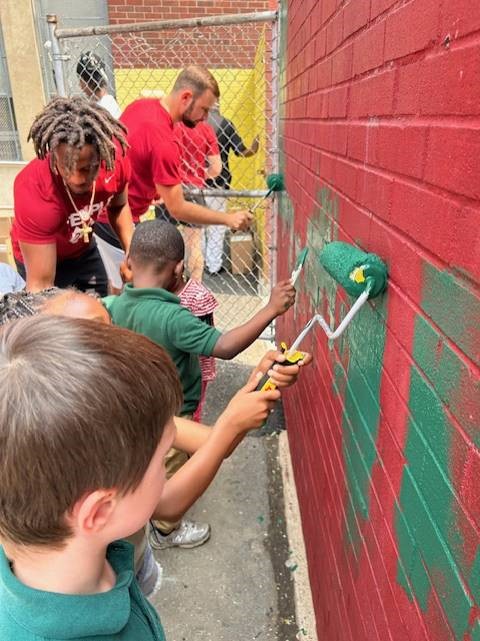 PFCU volunteers painted alongside members of the Temple Owls football team at Duckrey School, contributing to a school-wide beautification project.