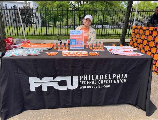 PFCU Business Development Specialist Yorkenia Gomez at PFCU booth distributing literature and free giveaways.