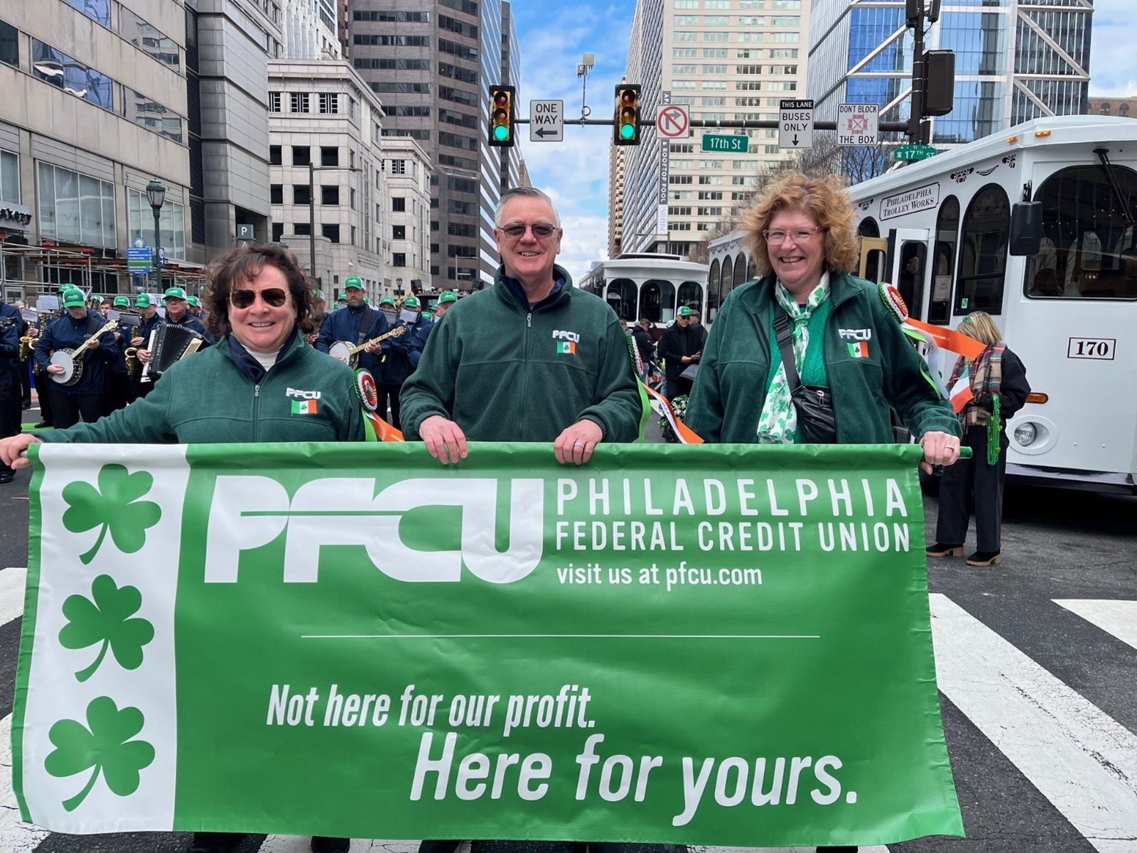 People holding PFCU banner at St. Patrick's Day Parade.